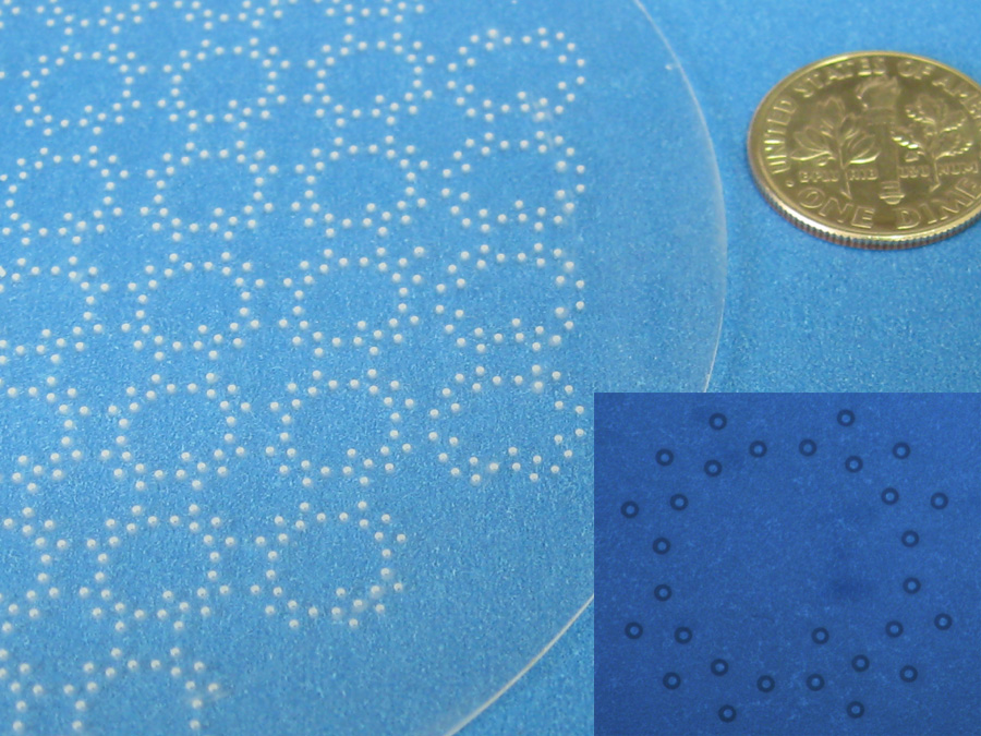 Holes cut into strengthened glass wafer using micro-precision sandblasting.