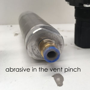 Damaged vent pinch from abrasive contamination.